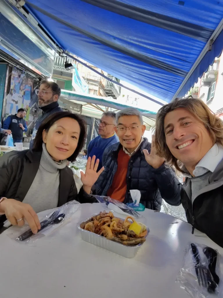 Couple of tourists and tour guide enjoying fresh seafood in a Neapolitan risto-pescheria