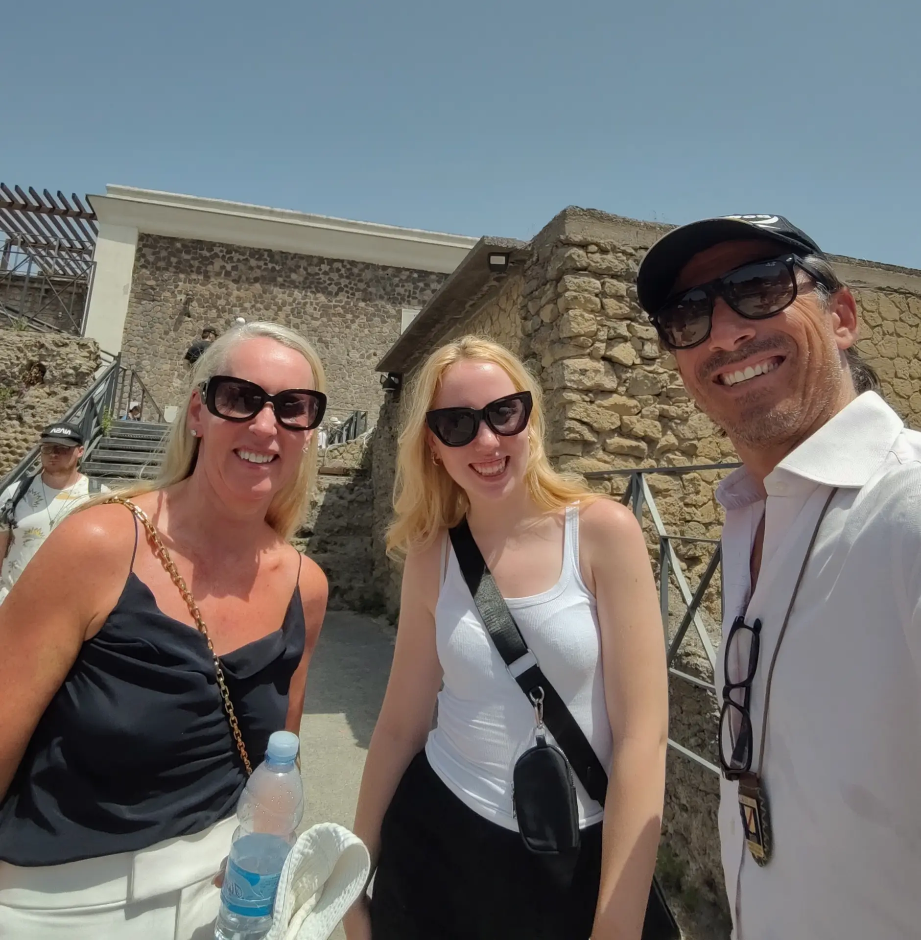 A group of tourists smiling during their tour in Pompeii